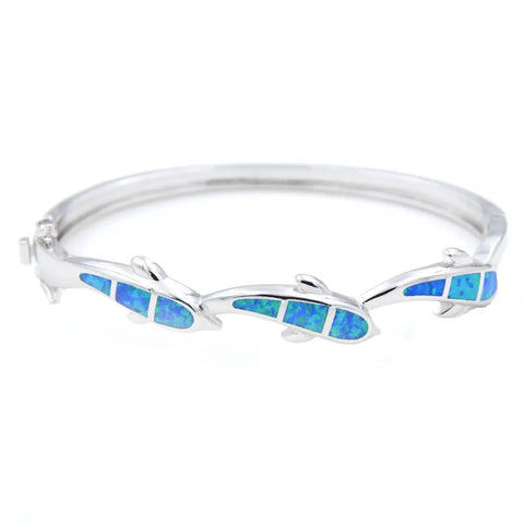 Silver dolphin bangle bracelet with vibrant blue opal inlays, symbol of protection