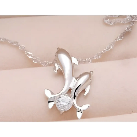 Silver dolphin pendant necklace with clear gemstone, symbol of love and ocean harmony