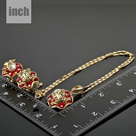 Gold-toned frog pendant with red enamel and gems, good luck symbol