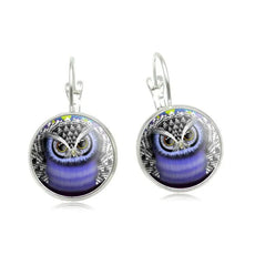 Silver lever-back owl earrings with purple glass dome on patterned background