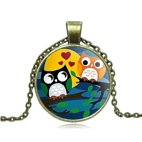 Owl necklace with black & orange cartoon owls on branch under moon, hearts in brass frame