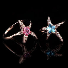 Rose gold starfish ring set with pink and blue crystal centers, ocean beauty design