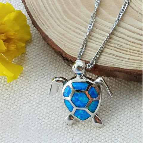 Silver turtle pendant necklace with blue opal inlay, symbol of protection