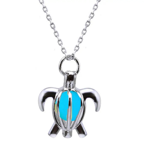 Silver turtle pendant necklace with glowing turquoise interior, symbol of protection